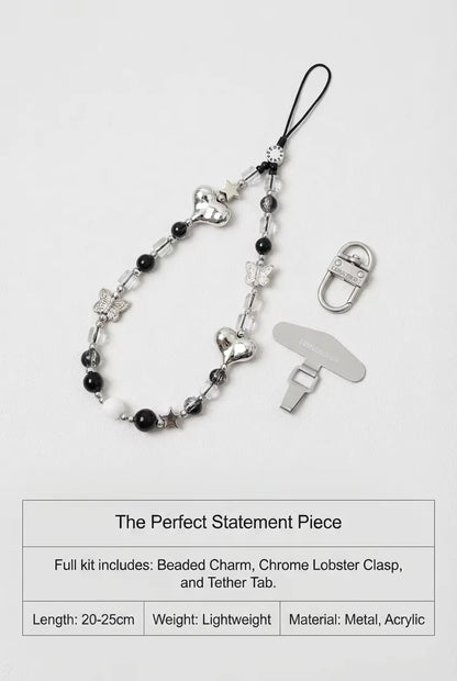 Beaded charm with chrome lobster clasp and tether tab on a white background