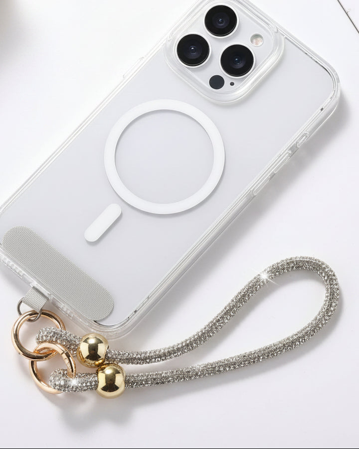 A clear mobile phone case with a luxury rhinestone lanyard attached to it, featuring a sparkling strap and rhinestone clasps.