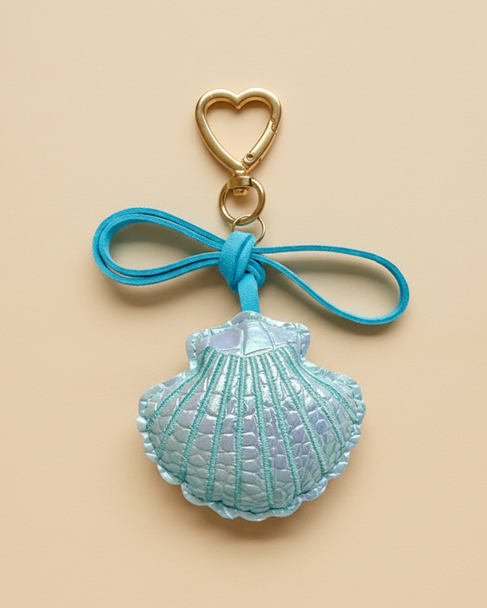 Blue shell keychain charm on a beige background