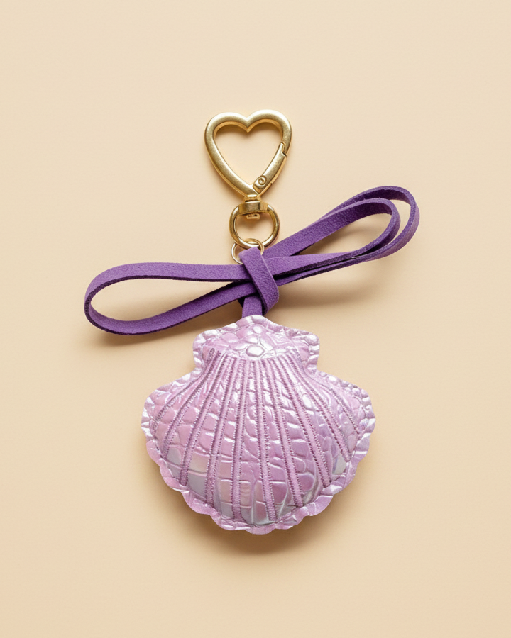 Purple-and-pink shell keychain charm on a beige background
