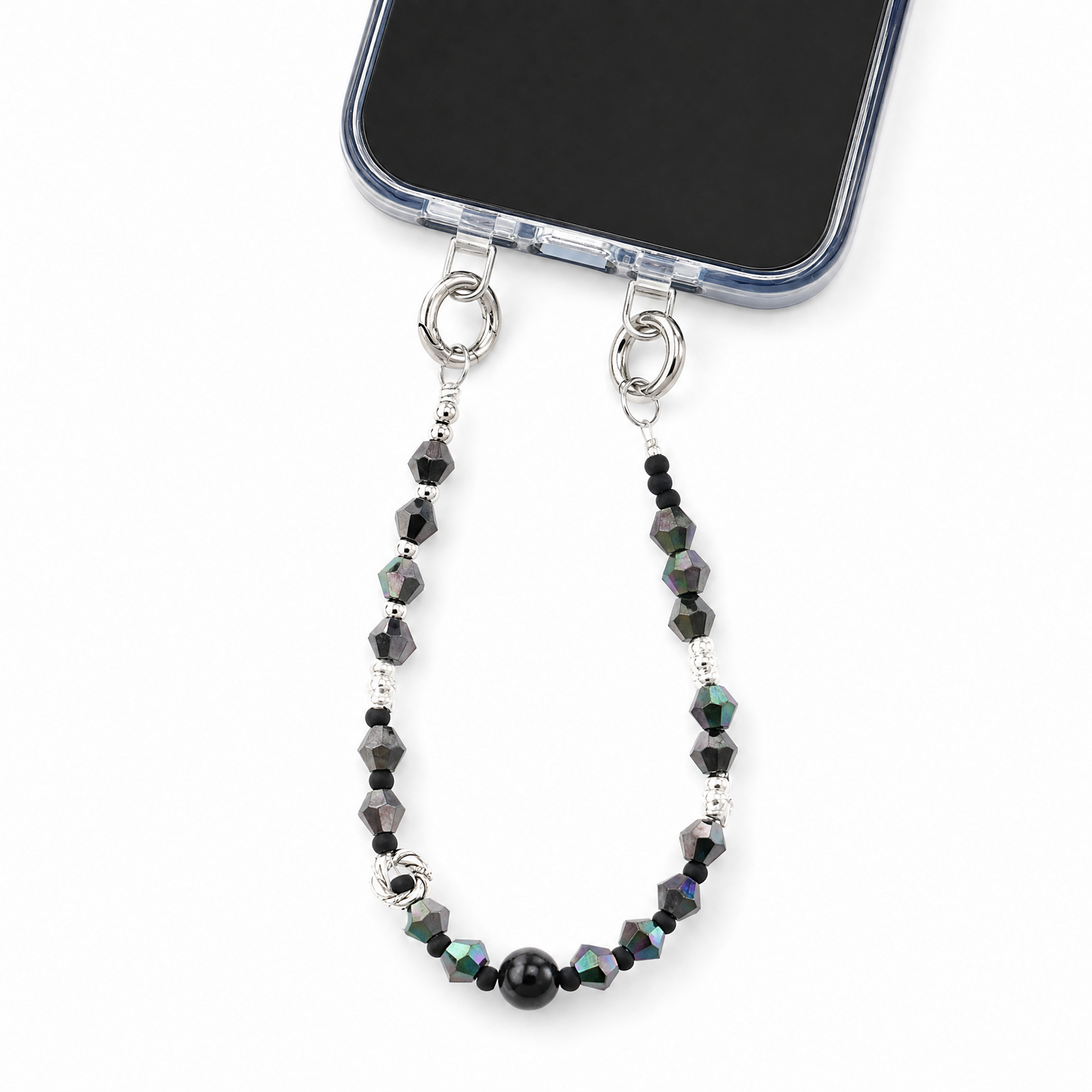 A silver metal phone strap with faceted black beads and iridescent accents, attached to a smartphone on a clean white background.